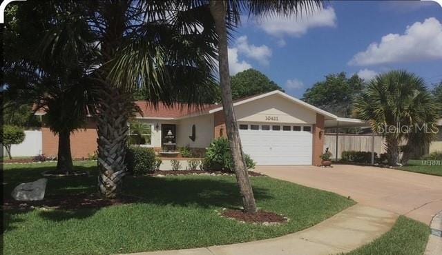 10411 E Leaning Oak Dr, Port Richey, FL 34668 - ranch-style house with a garage, concrete driveway, and stucco siding