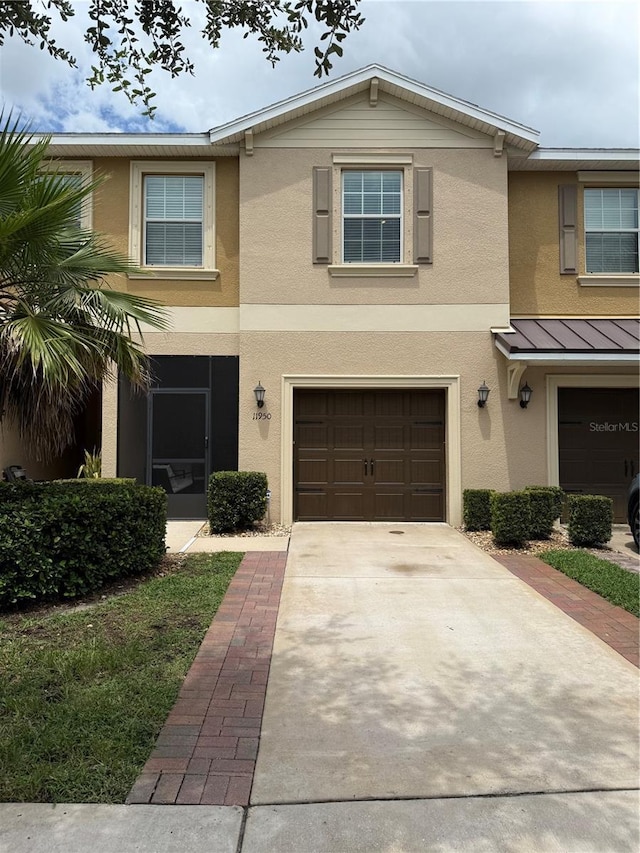 11950 Greengate Dr, Hudson, FL 34669 - view of front of house with stucco siding, an attached garage, a standing seam roof, driveway, and a metal roof