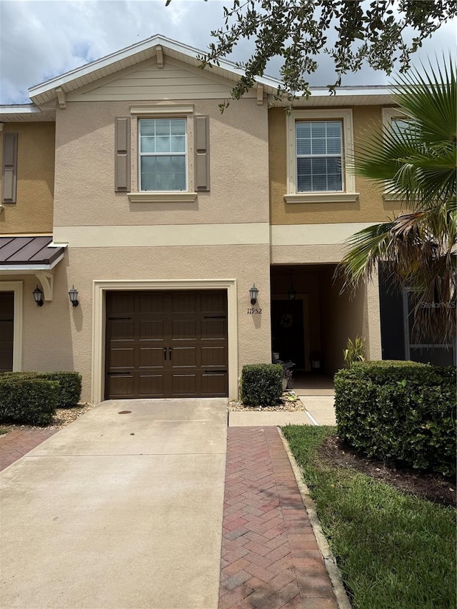 11952 Greengate Dr, Hudson, FL 34669 - view of front of house with stucco siding, an attached garage, driveway, a standing seam roof, and a metal roof