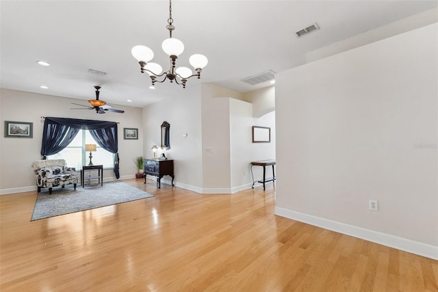 15604 Durango Cir, Brooksville, FL 34604 - unfurnished living room featuring light wood-style floors, ceiling fan, a chandelier, recessed lighting, and arched walkways