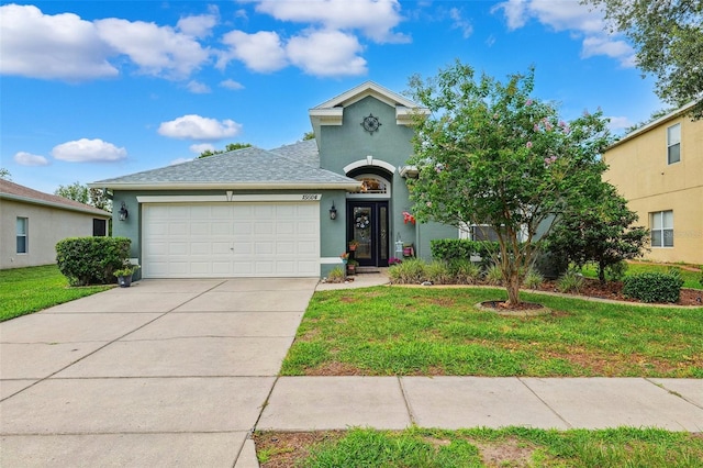 15604 Durango Cir, Brooksville, FL 34604 - view of front facade featuring stucco siding, an attached garage, and a front yard
