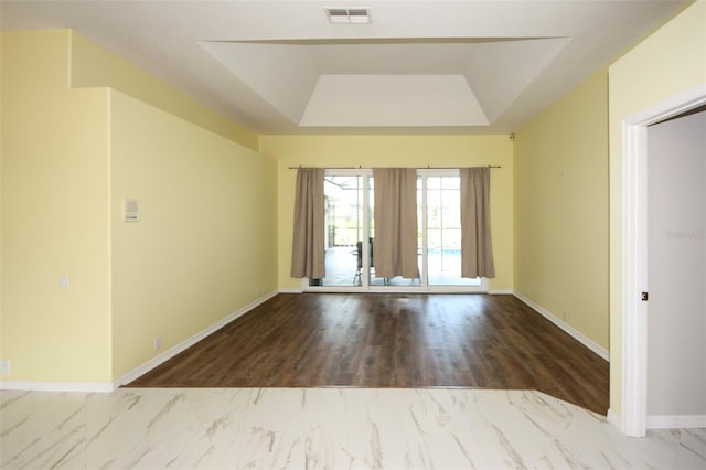 8311 Coral Creek Loop, Hudson, FL 34667 - unfurnished room featuring a raised ceiling and marble look tile flooring