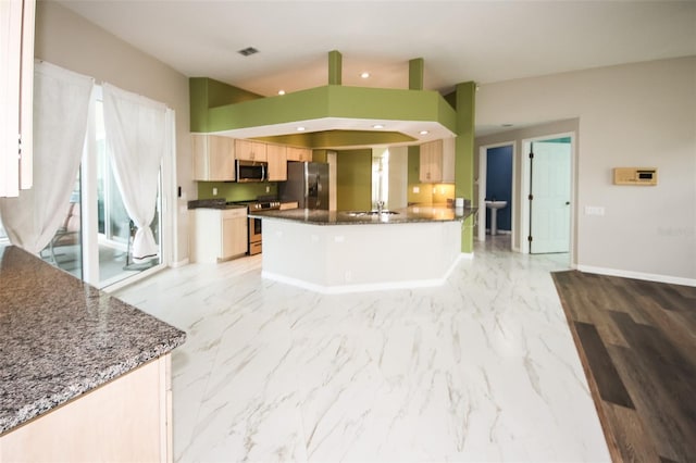 8311 Coral Creek Loop, Hudson, FL 34667 - kitchen featuring stainless steel appliances, a peninsula, light marble finish floors, dark stone countertops, and light brown cabinets