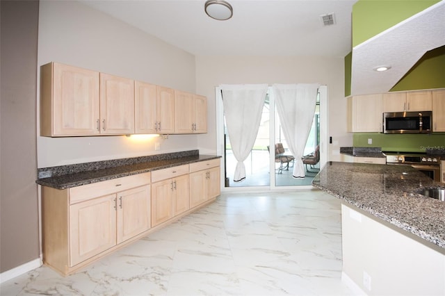 8311 Coral Creek Loop, Hudson, FL 34667 - kitchen with appliances with stainless steel finishes, light brown cabinetry, dark stone counters, recessed lighting, and light marble finish flooring