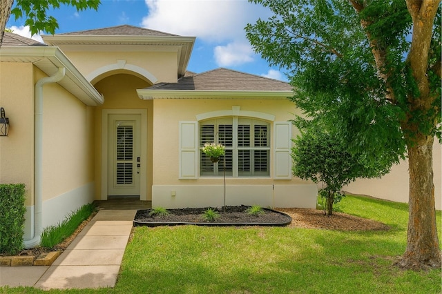 14647 Potterton Cir, Hudson, FL 34667 - view of exterior entry featuring a lawn and stucco siding