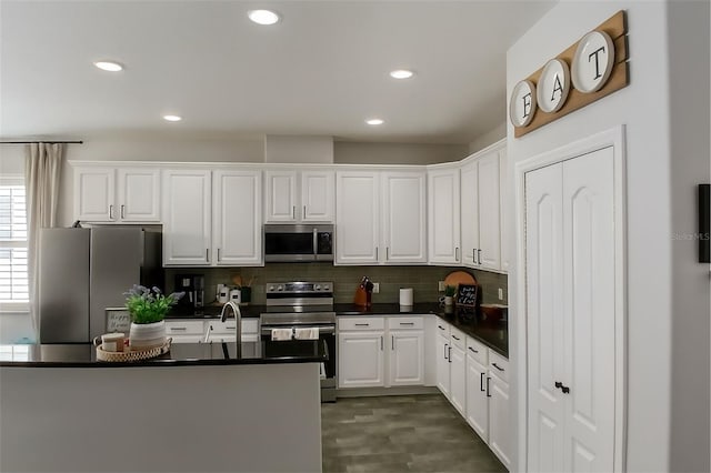 14647 Potterton Cir, Hudson, FL 34667 - kitchen featuring stainless steel appliances, dark countertops, white cabinetry, backsplash, and recessed lighting