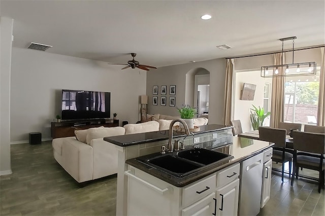 14647 Potterton Cir, Hudson, FL 34667 - kitchen featuring dishwasher, open floor plan, a center island, dark countertops, and white cabinetry