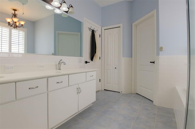 14647 Potterton Cir, Hudson, FL 34667 - full bath with a chandelier, vanity, tile patterned flooring, a bath, and tile walls