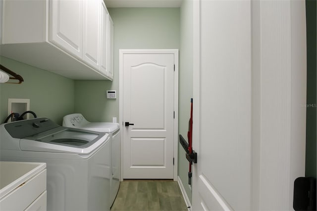 14647 Potterton Cir, Hudson, FL 34667 - laundry area featuring cabinet space, washing machine and dryer, and wood finished floors