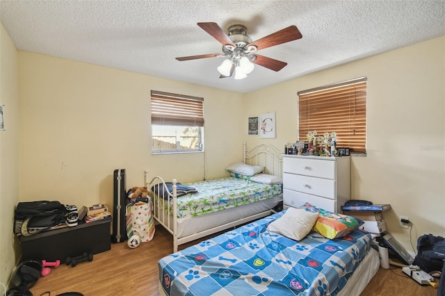 6428 Kentfield Ave, New Port Richey, FL 34653 - bedroom with wood finished floors, ceiling fan, and a textured ceiling