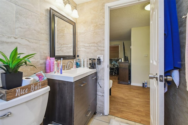 6428 Kentfield Ave, New Port Richey, FL 34653 - bathroom with vanity, tile walls, and wood finished floors