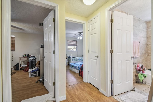 6428 Kentfield Ave, New Port Richey, FL 34653 - hall featuring a textured ceiling and light wood-style floors
