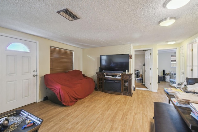 6428 Kentfield Ave, New Port Richey, FL 34653 - living room featuring a textured ceiling and light wood-style floors