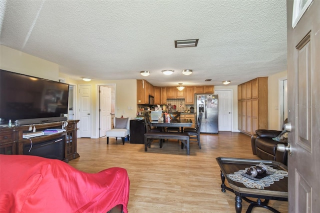 6428 Kentfield Ave, New Port Richey, FL 34653 - living area featuring light wood-style floors and a textured ceiling