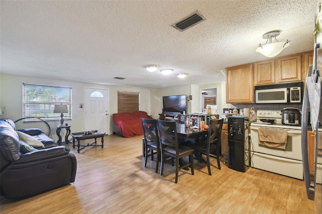 6428 Kentfield Ave, New Port Richey, FL 34653 - kitchen with electric stove, open floor plan, light wood finished floors, a textured ceiling, and decorative backsplash