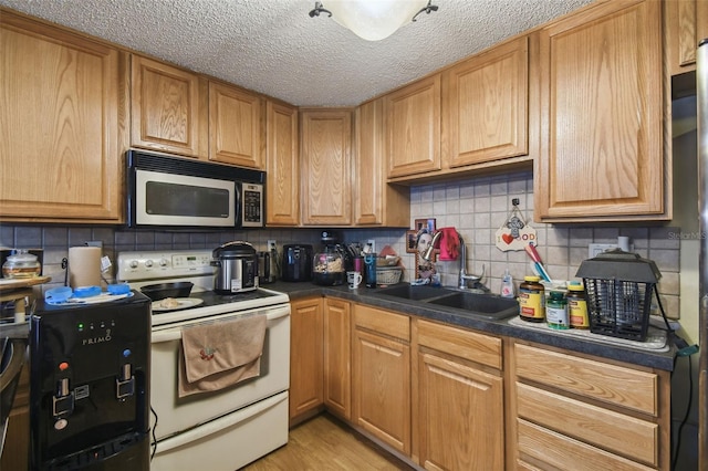 6428 Kentfield Ave, New Port Richey, FL 34653 - kitchen featuring white electric stove, stainless steel microwave, dark countertops, decorative backsplash, and a textured ceiling