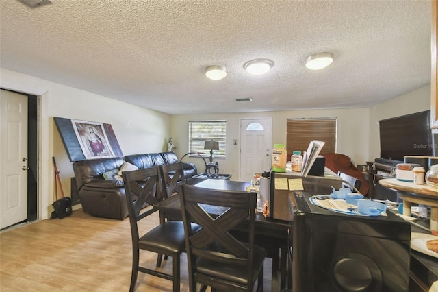 6428 Kentfield Ave, New Port Richey, FL 34653 - dining space featuring light wood-style flooring and a textured ceiling