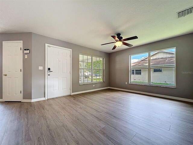 12214 Partridge Hill Row, Hudson, FL 34667 - foyer entrance with wood finished floors, a ceiling fan, and a textured ceiling