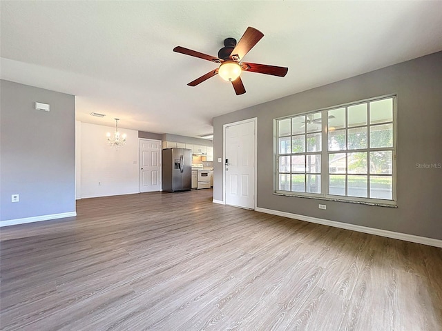 12214 Partridge Hill Row, Hudson, FL 34667 - unfurnished living room featuring a chandelier, a ceiling fan, and wood finished floors