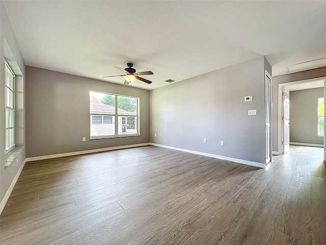 12214 Partridge Hill Row, Hudson, FL 34667 - empty room featuring wood finished floors, a ceiling fan, and plenty of natural light