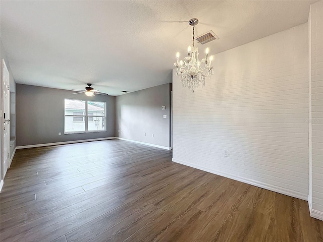 12214 Partridge Hill Row, Hudson, FL 34667 - empty room featuring ceiling fan, a chandelier, and dark wood finished floors