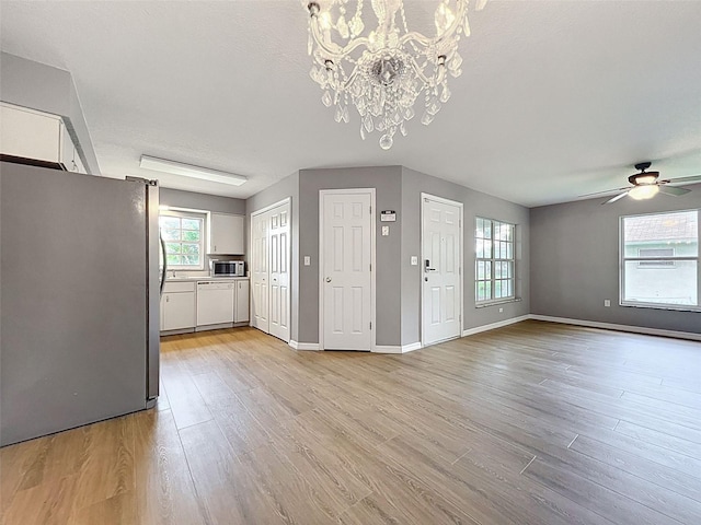 12214 Partridge Hill Row, Hudson, FL 34667 - kitchen with appliances with stainless steel finishes, a chandelier, white cabinets, light wood-style flooring, and ceiling fan