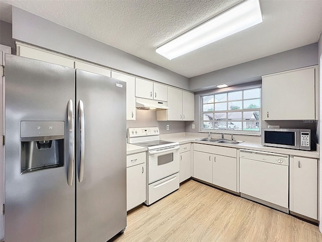 12214 Partridge Hill Row, Hudson, FL 34667 - kitchen featuring appliances with stainless steel finishes, under cabinet range hood, light wood-type flooring, light countertops, and white cabinets