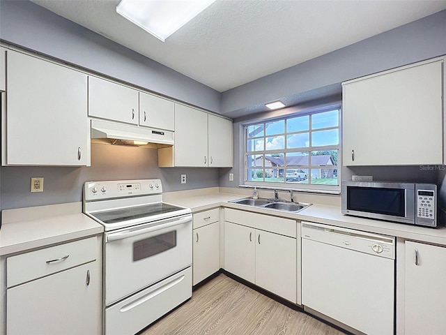 12214 Partridge Hill Row, Hudson, FL 34667 - kitchen with white appliances, under cabinet range hood, light countertops, light wood-style floors, and white cabinets
