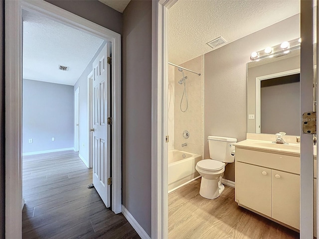 12214 Partridge Hill Row, Hudson, FL 34667 - bathroom with a textured ceiling, wood finished floors, shower / washtub combination, and vanity