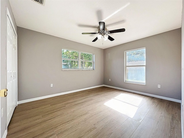 12214 Partridge Hill Row, Hudson, FL 34667 - empty room featuring healthy amount of natural light, wood finished floors, and ceiling fan