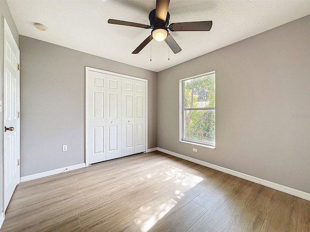 12214 Partridge Hill Row, Hudson, FL 34667 - unfurnished bedroom featuring wood finished floors, a closet, and a ceiling fan