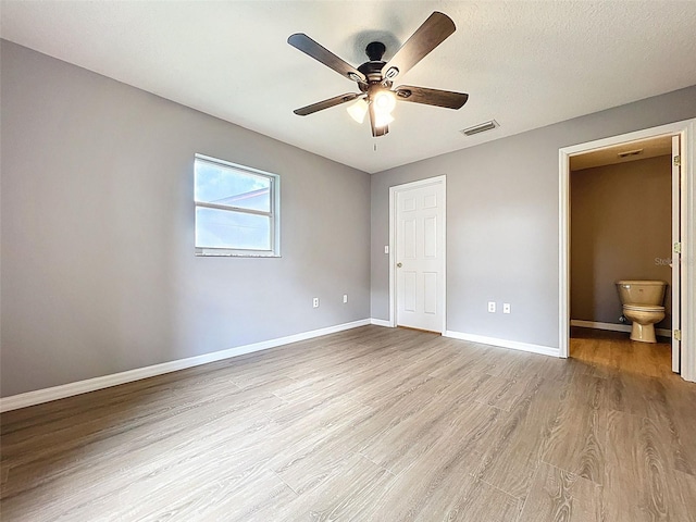 12214 Partridge Hill Row, Hudson, FL 34667 - unfurnished bedroom with light wood finished floors, ensuite bathroom, and ceiling fan