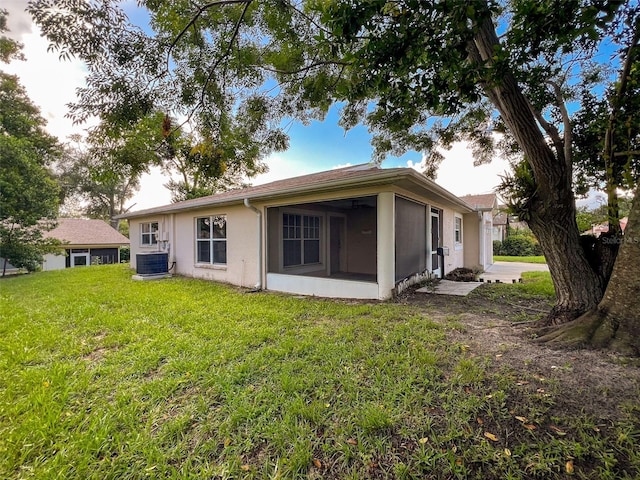 12214 Partridge Hill Row, Hudson, FL 34667 - back of property featuring a sunroom, stucco siding, and a yard