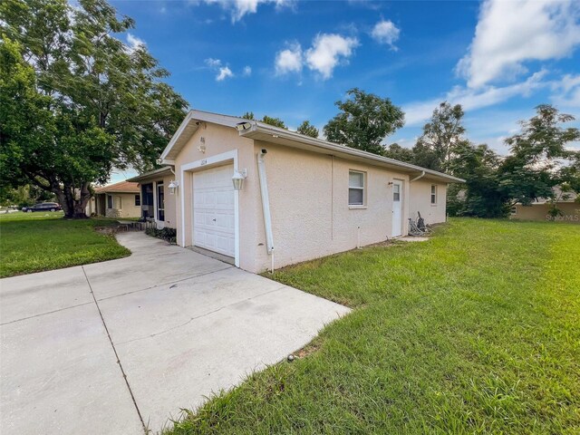 12214 Partridge Hill Row, Hudson, FL 34667 - view of property exterior with concrete driveway, stucco siding, a yard, and an attached garage