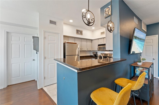 2010 E Palm Ave Unit 14312, Tampa, FL 33605 - kitchen with appliances with stainless steel finishes, a peninsula, light wood-style floors, a breakfast bar, and recessed lighting