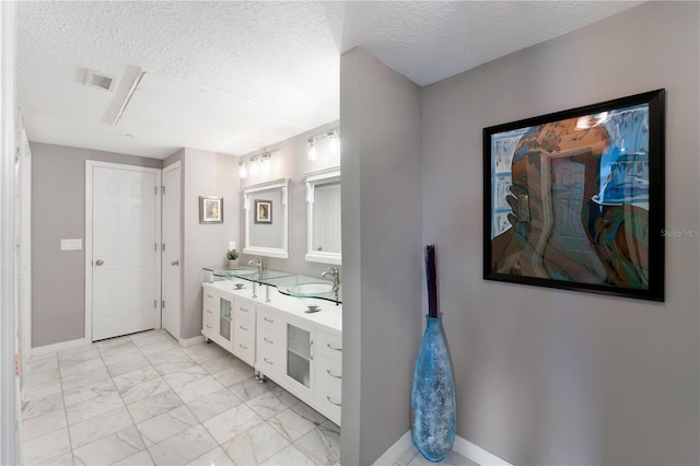 2010 E Palm Ave Unit 14312, Tampa, FL 33605 - bathroom featuring double vanity, marble finish floors, and a textured ceiling