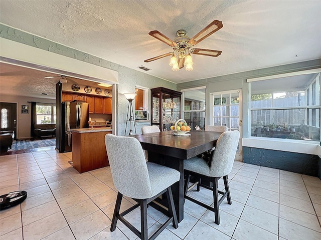 8640 Horizon Ln, Hudson, FL 34667 - dining room with light tile patterned flooring, ceiling fan, and a textured ceiling
