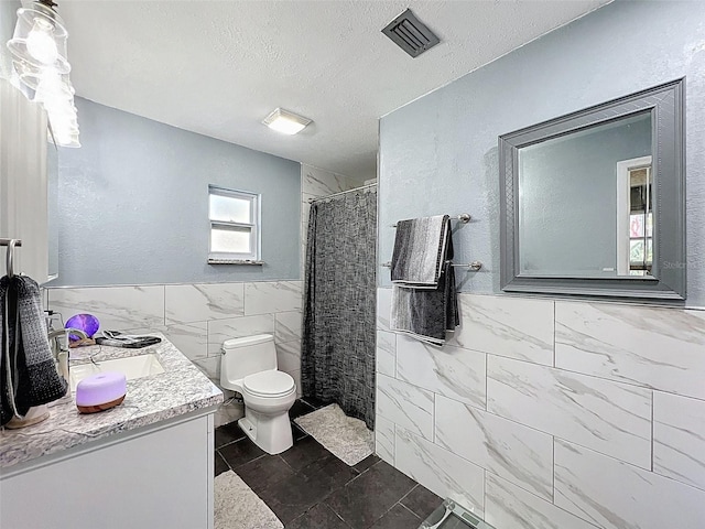 8640 Horizon Ln, Hudson, FL 34667 - bathroom with tile walls, vanity, a shower with curtain, a textured ceiling, and wainscoting
