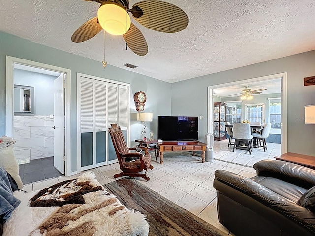 8640 Horizon Ln, Hudson, FL 34667 - living area featuring a ceiling fan, light tile patterned flooring, and a textured ceiling