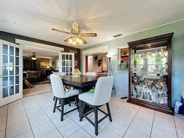 8640 Horizon Ln, Hudson, FL 34667 - dining space featuring french doors, a textured wall, ceiling fan, light tile patterned floors, and a textured ceiling