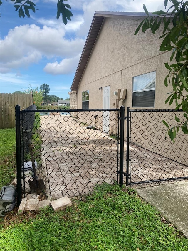 7806 Jenner Ave, New Port Richey, FL 34655 - view of property exterior featuring a gate and stucco siding