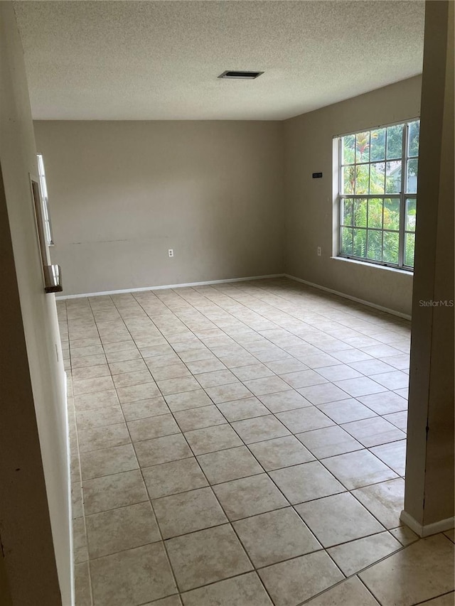 7806 Jenner Ave, New Port Richey, FL 34655 - spare room featuring a textured ceiling and light tile patterned flooring