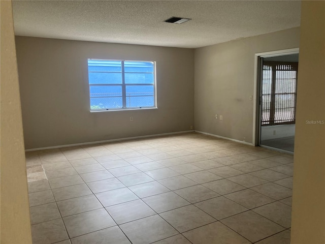 7806 Jenner Ave, New Port Richey, FL 34655 - tiled spare room featuring plenty of natural light and a textured ceiling