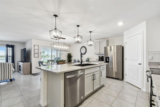 11861 Downy Birch Dr, Riverview, FL 33569 - kitchen featuring appliances with stainless steel finishes, light tile patterned flooring, a center island with sink, and decorative light fixtures
