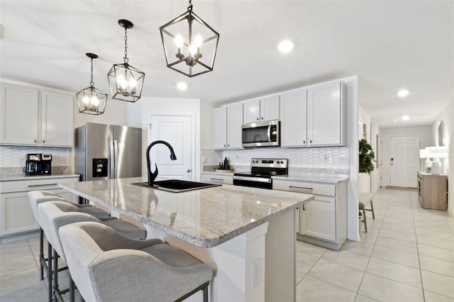 11861 Downy Birch Dr, Riverview, FL 33569 - kitchen featuring stainless steel appliances, a chandelier, decorative backsplash, light tile patterned floors, and a breakfast bar area