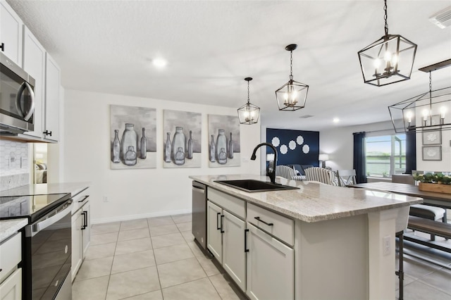 11861 Downy Birch Dr, Riverview, FL 33569 - kitchen with stainless steel appliances, a chandelier, hanging light fixtures, light stone countertops, and an island with sink