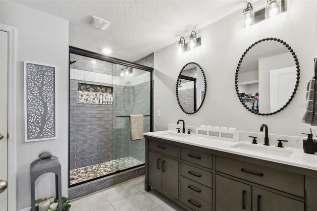 11861 Downy Birch Dr, Riverview, FL 33569 - full bathroom featuring double vanity, a shower stall, tile patterned floors, and a textured ceiling