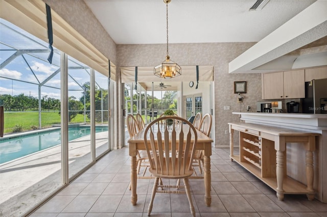 8921 Kilmer Way, Hudson, FL 34667 - dining area featuring wallpapered walls, light tile patterned floors, and a chandelier