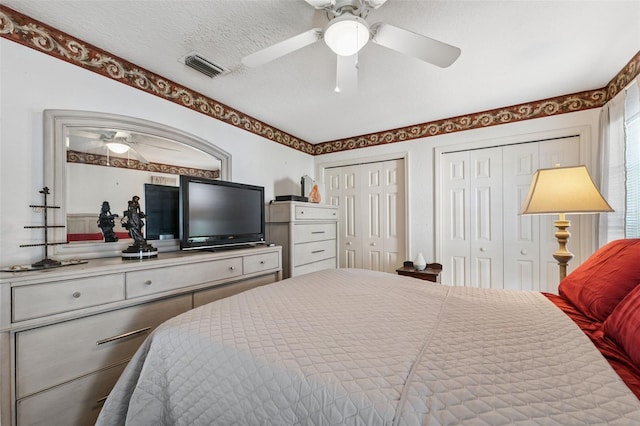 8921 Kilmer Way, Hudson, FL 34667 - bedroom featuring two closets, a ceiling fan, and a textured ceiling