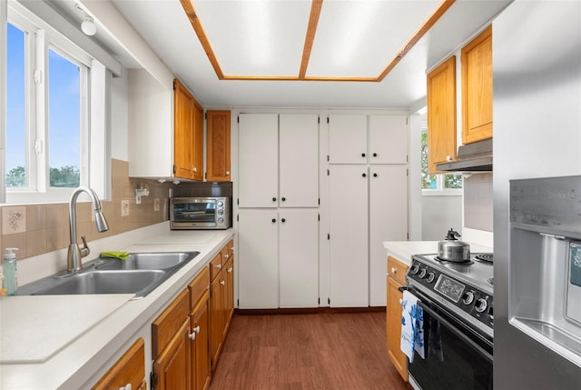 13825 San Juan Ave, Hudson, FL 34667 - kitchen with black electric range, stainless steel fridge with ice dispenser, wood finished floors, under cabinet range hood, and light countertops